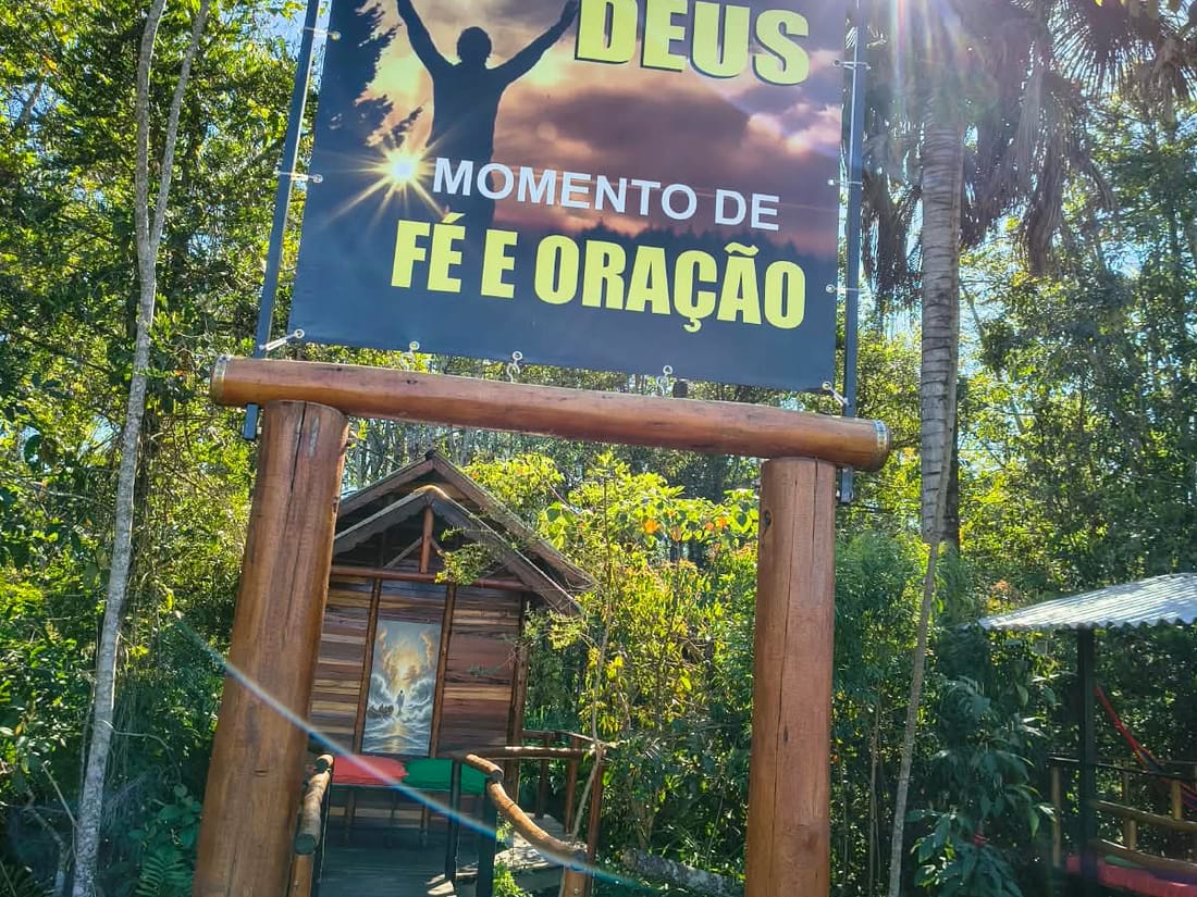 Passarela de madeira para o espaço de retiro e oração, no meio da mata