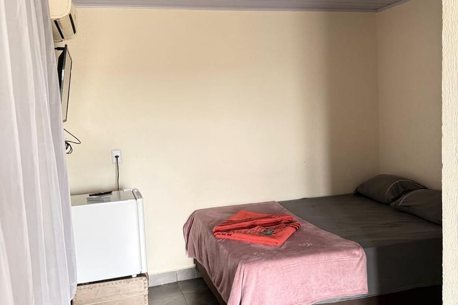 Quarto da suíte Maracanã com cama de casal e frigobar